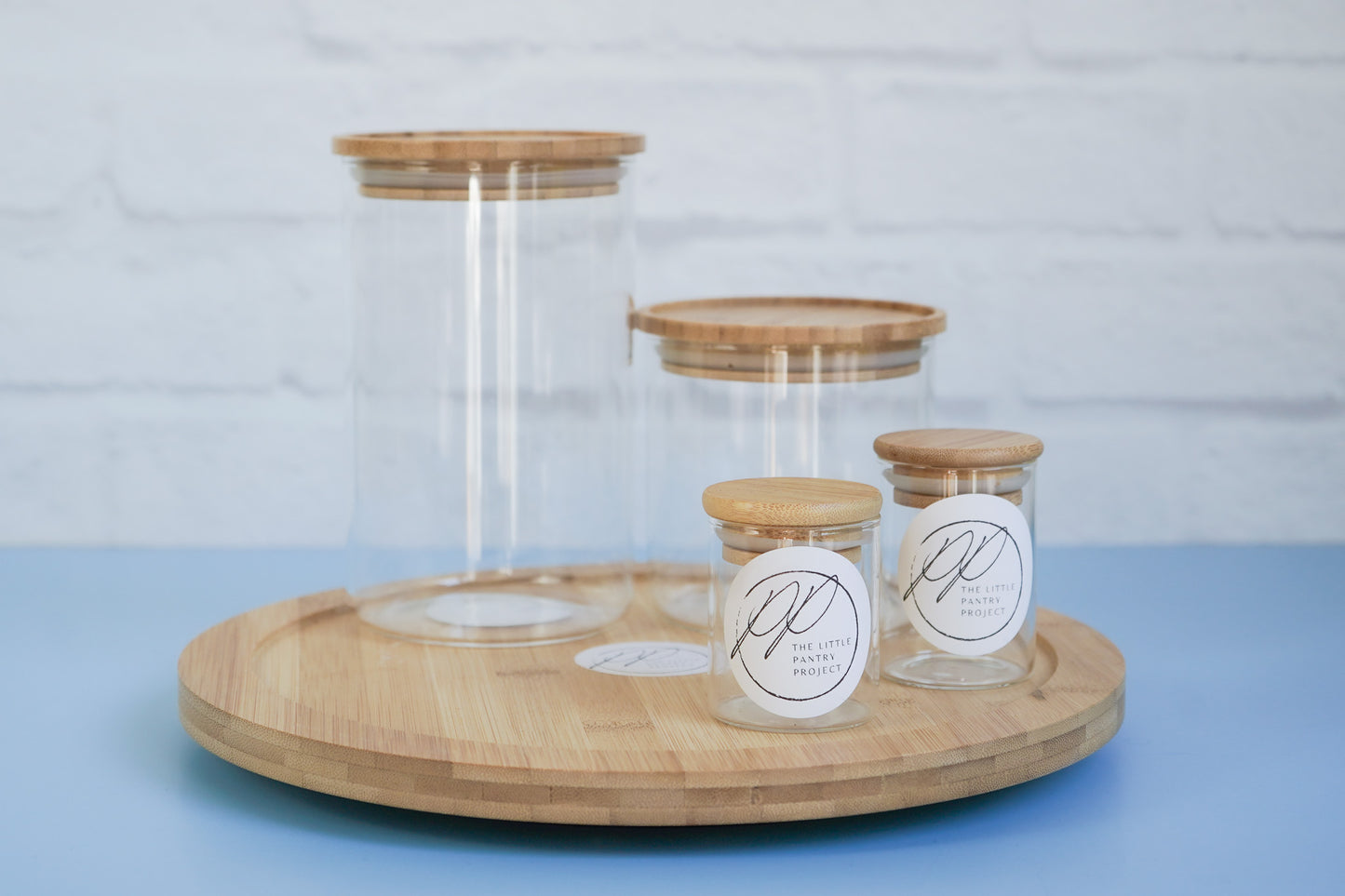 The bamboo turn table from The Little Pantry Project with an assortment of glass canisters on it.